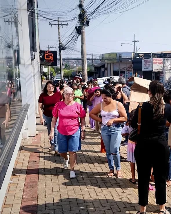 Fila de clientes pela calçada antes da loja abrir