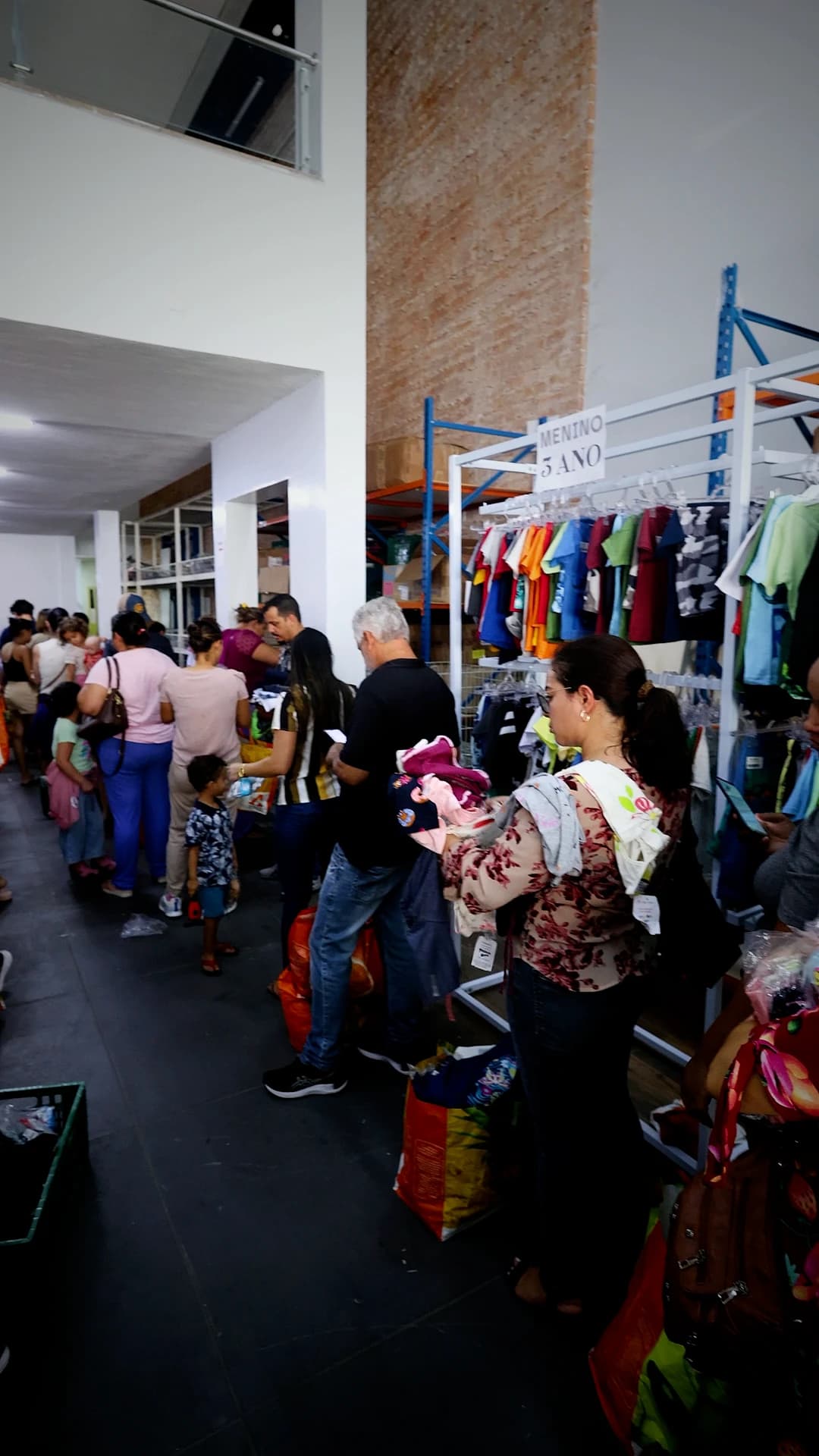 Clientes em fila dentro da loja com peças na mão